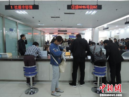 尽管服务窗口前有便民座椅，但是大多数市民仍愿意把便民座椅搁置一旁，弯着腰趴在服务窗台上与工作人员交流。 韩章云 摄